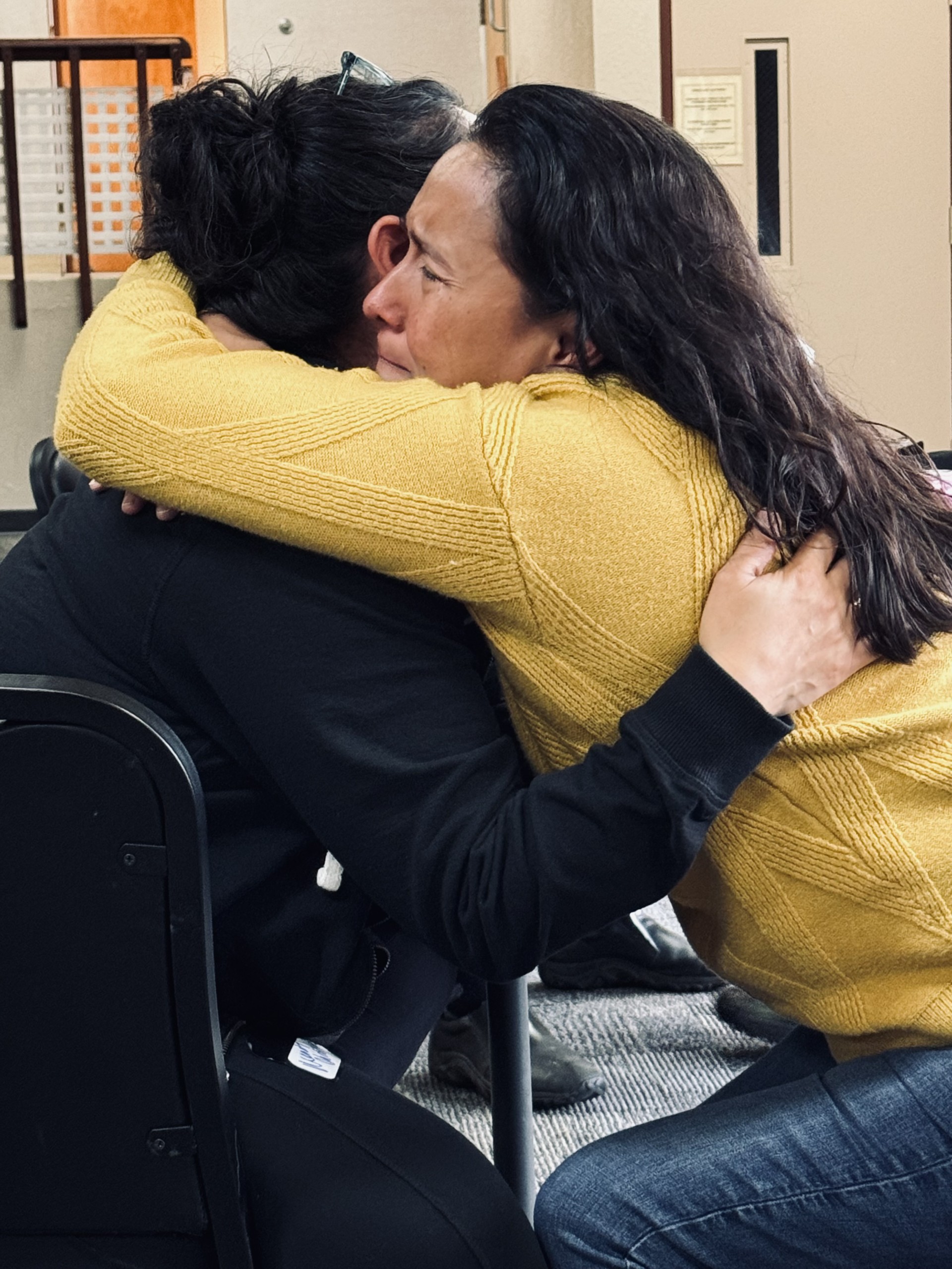 Two people embracing at a healing session