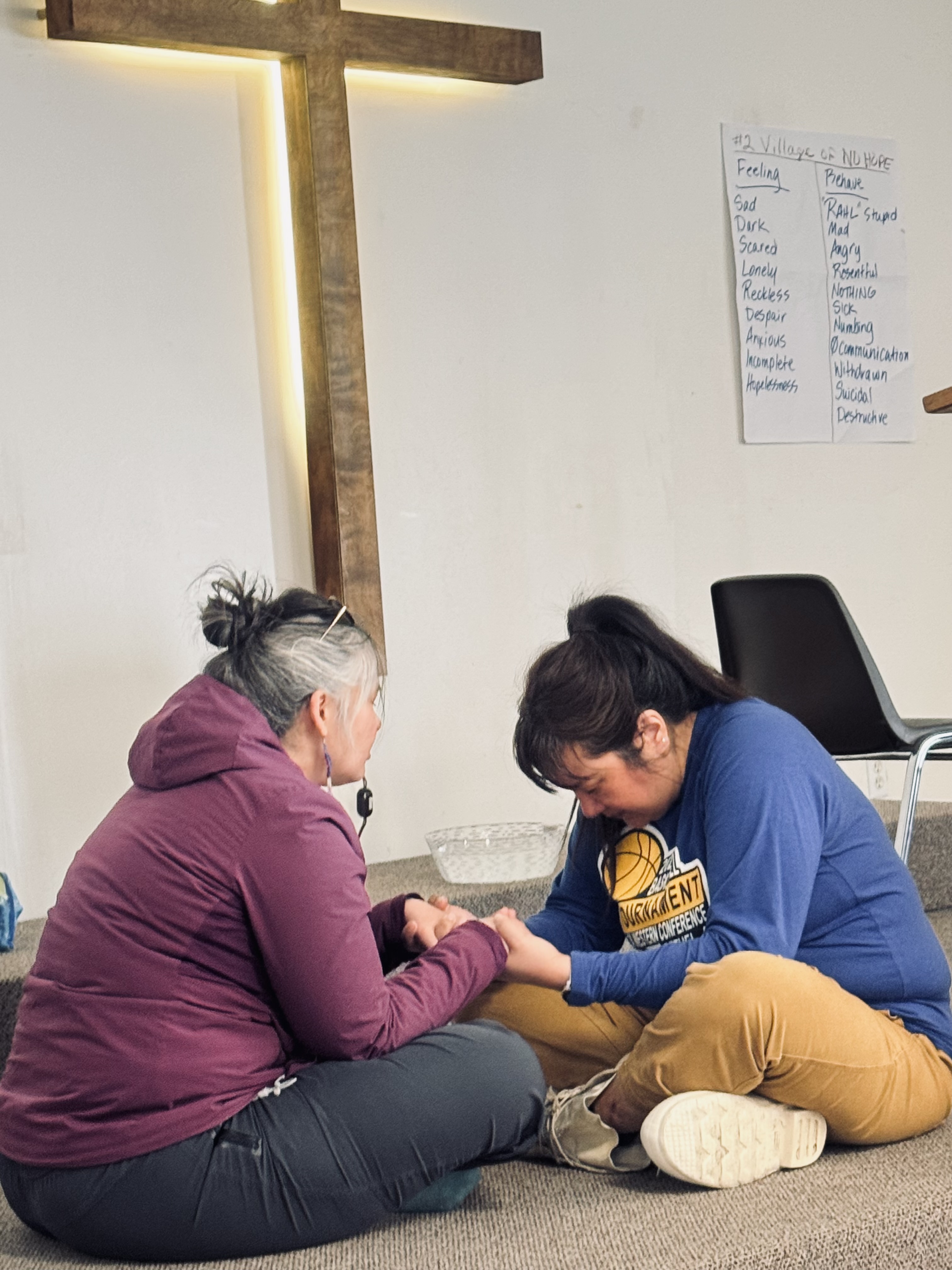 Women praying before the cross at a healing group